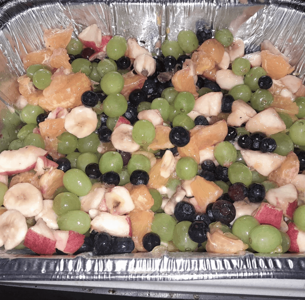 A beautiful fruit salad with grapes, berries, bananas, and other fresh fruits